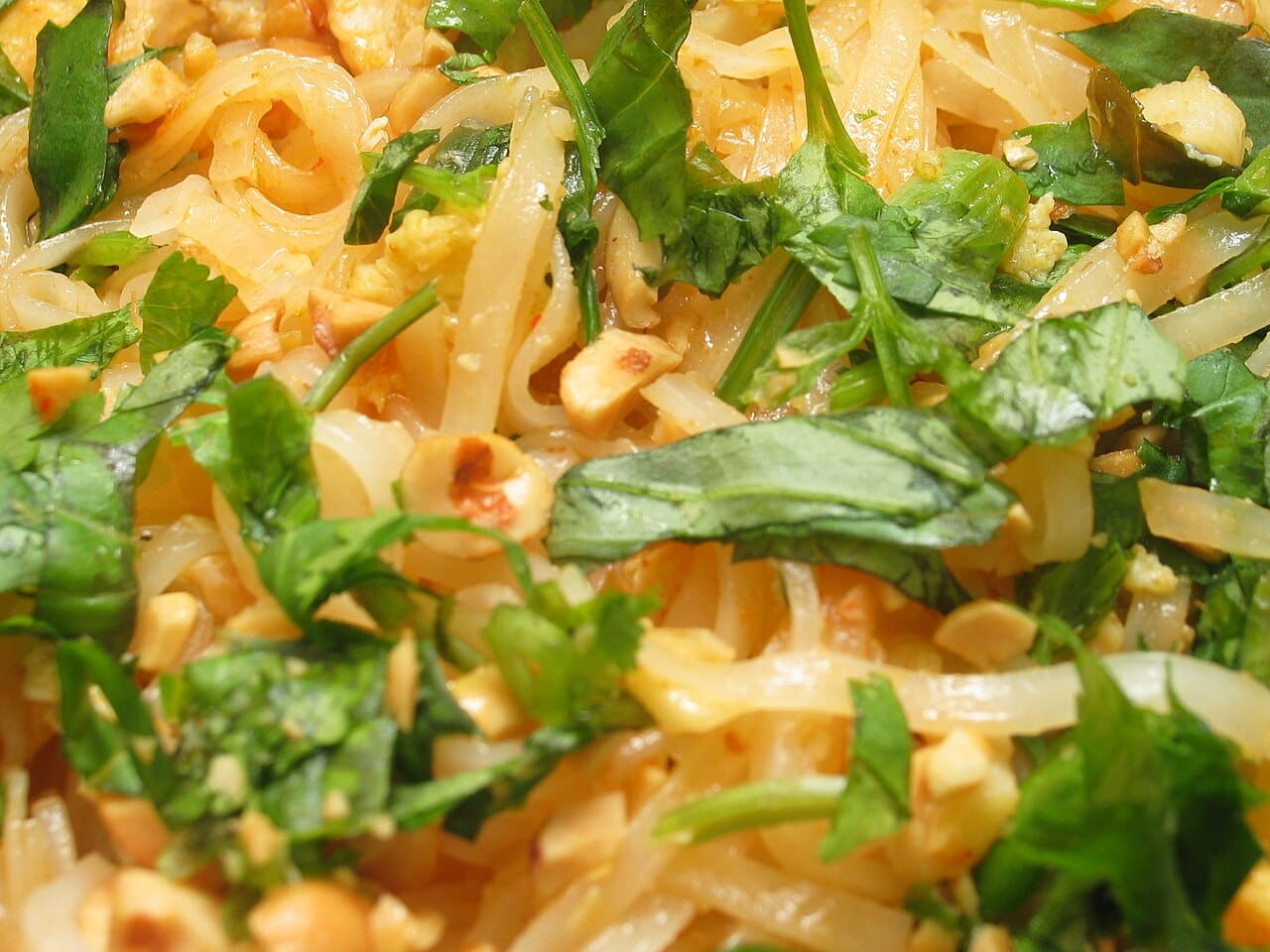 A plate of Pad Thai with rice noodles, peanuts, bean sprouts and lime